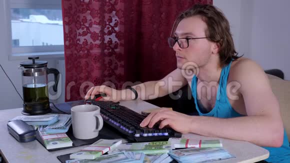 专注的男人在家里用台式电脑在网上赚钱视频的预览图