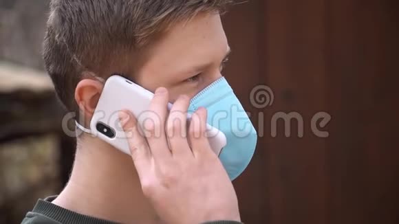 戴着医用面罩的年轻人看着摄像机保护身体免受冠状病毒感染戴着医用面罩的19岁年轻人在p上交谈视频的预览图