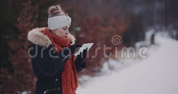 积极妇女使用数字平板在冬季户外视频的预览图