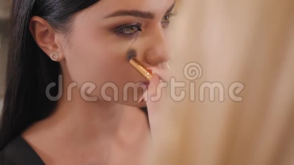化妆师用刷子在面部涂上化妆品色调视频的预览图