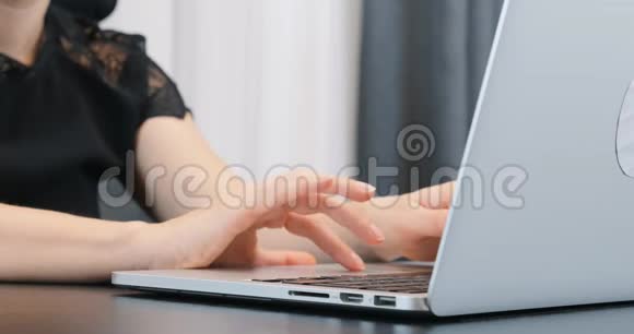 女士类型的笔记本电脑键盘穿黑色裙子的商务女士在办公室工作合上电脑上的女性手视频的预览图