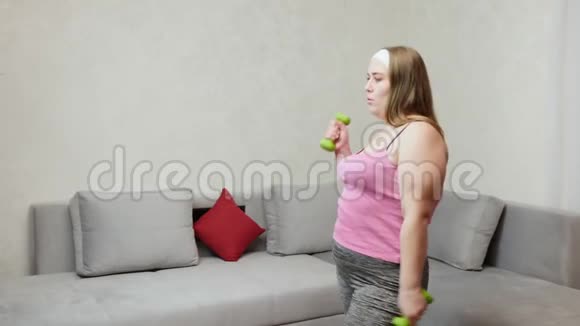 胖女人在房间里用哑铃做运动视频的预览图