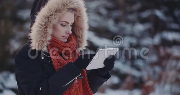 积极妇女使用数字平板在冬季户外视频的预览图