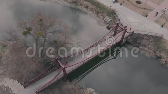 在公园和码头的娱乐区女人在跨河的桥上奔跑女运动员在公园练习跑步视频的预览图