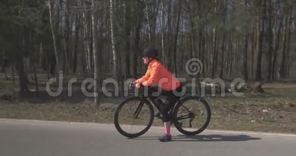骑自行车的女人的肖像戴着头盔的女自行车骑在森林里三项运动员准备户外训练骑自行车和视频的预览图