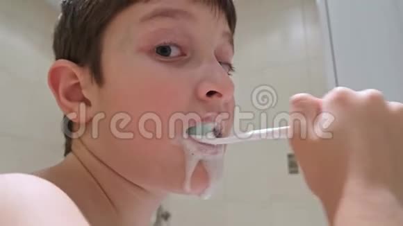 一张白种人少年在浴室刷牙的照片特写视频的预览图