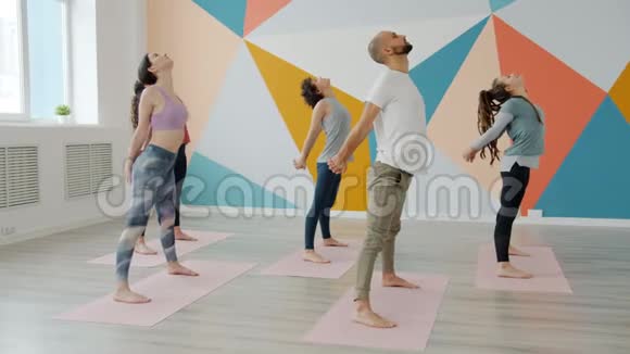 一群在瑜伽练习中穿着运动服向前弯曲的年轻人视频的预览图