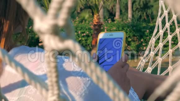 夏天在花园里使用智能手机的快乐女人视频的预览图
