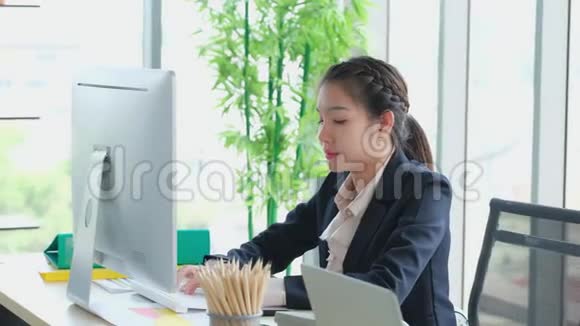 早上年轻的亚洲女性独自在办公室打字从事计算机工作的商业妇女视频的预览图