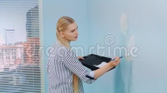 女人在蓝墙上画一朵花视频的预览图