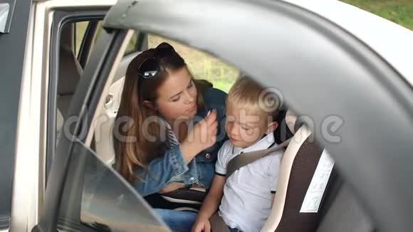 母亲和儿子在车里的肖像男孩系着安全带视频的预览图