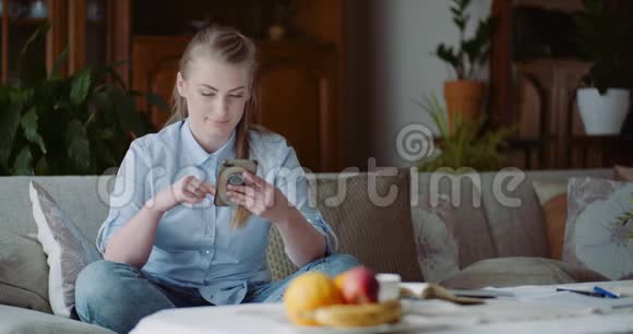 快乐的女人在家里浏览智能手机在家庭办公室工作的女商人视频的预览图