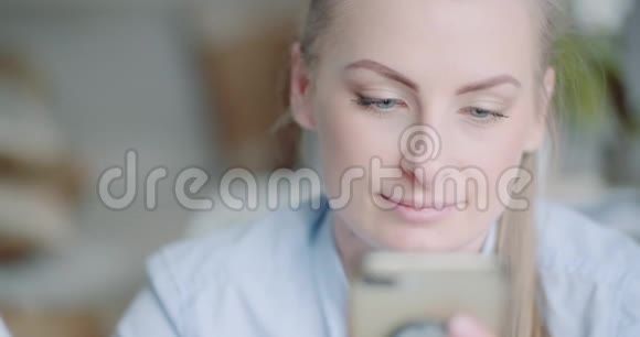 美丽的女人使用智能手机和微笑视频的预览图