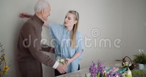 复活节快乐年轻女子送给祖父复活节礼物视频的预览图