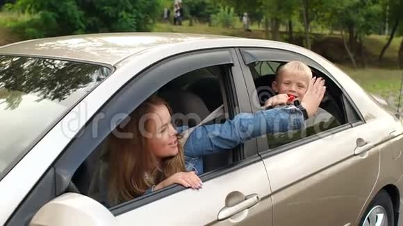 一个小男孩探出车窗拍了拍妈妈的胳膊视频的预览图
