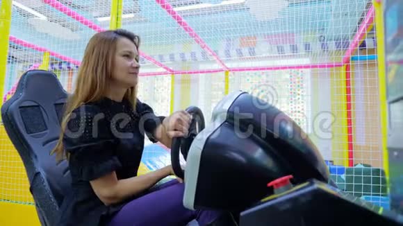 年轻女子在汽车模拟器上玩得开心视频的预览图