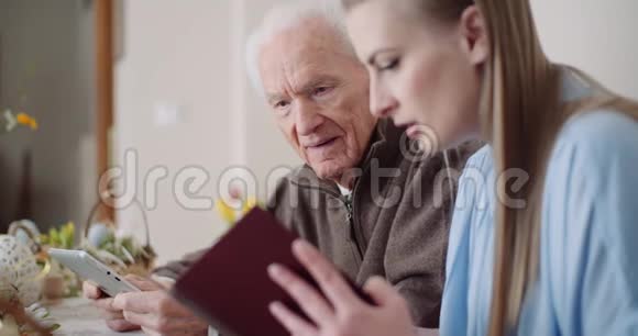 年轻女子在数码平板电脑上与祖父上网视频的预览图