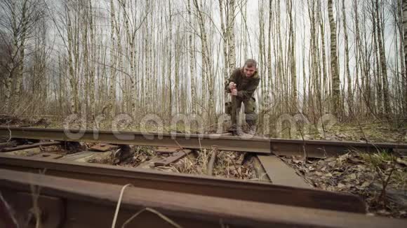 白种人工人在秋天的森林里切换铁路轨道的箭头机构视频的预览图