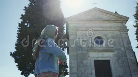 戴围巾的女人站在CappelladiVitaleta附近交叉自己侧景阳光明媚视频的预览图