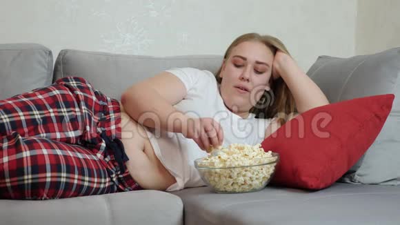 胖女孩躺在沙发上吃爆米花视频的预览图
