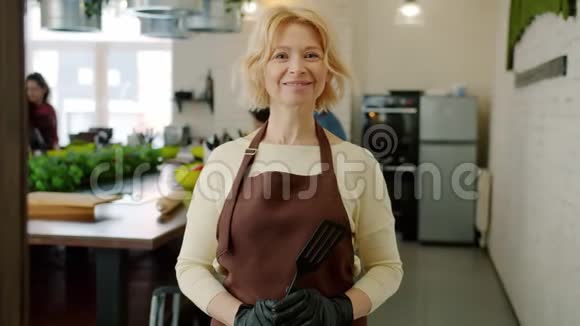室内烹饪课上穿围裙的快乐成年女子的画像视频的预览图