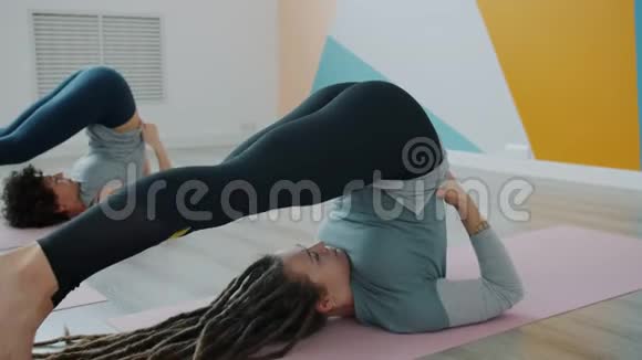 现代体育中心灵活的年轻人在垫子上练习反向瑜伽姿势视频的预览图