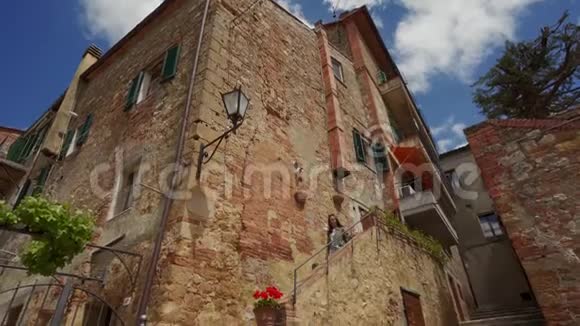 英美人沿着古城老建筑的石墙走下楼梯视频的预览图