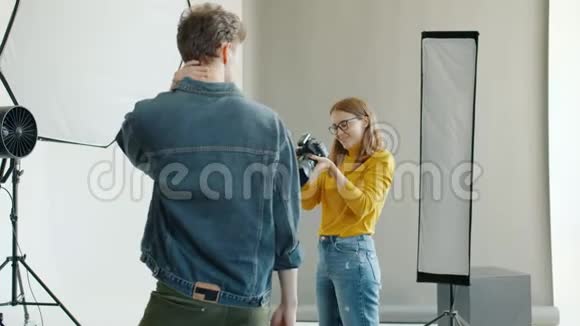 摄影棚用摄像机拍摄男性模特照片的慢镜头视频的预览图