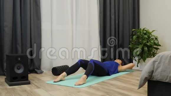 安装女性泵压力和训练在家做腹肌锻炼的年轻女子在地板上嘎吱嘎吱作响黑发视频的预览图