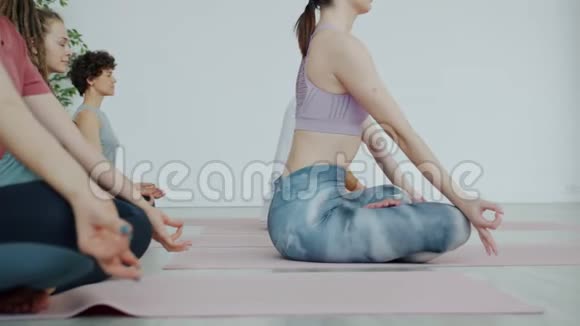 一组年轻人在室内瑜伽练习中坐莲冥想视频的预览图
