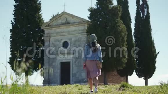 戴头巾的女孩在阳光明媚的日子接近卡佩拉迪维塔教堂后方视频的预览图