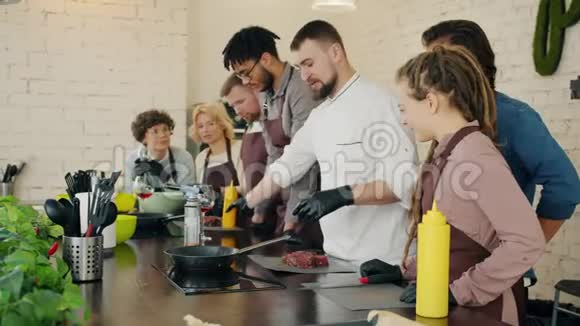 男厨师教学组学员烹饪肉类厨房讨论菜肴视频的预览图
