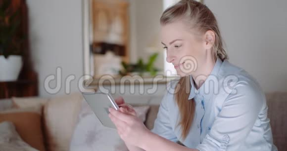 轻松微笑的女人在家里用手机聊天视频的预览图
