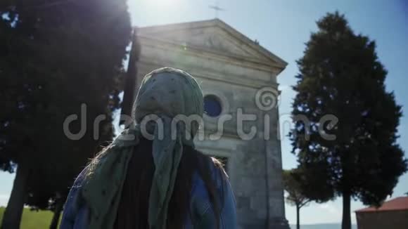 戴围巾的女人站在CappelladiVitaleta附近交叉自己太阳光线礼拜堂视频的预览图