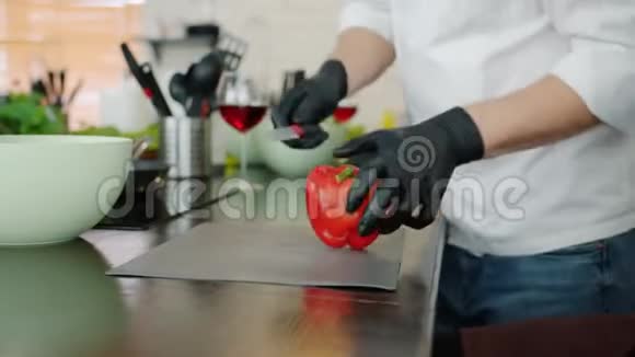 厨房里男人手上的特写切胡椒的烹饪沙拉视频的预览图
