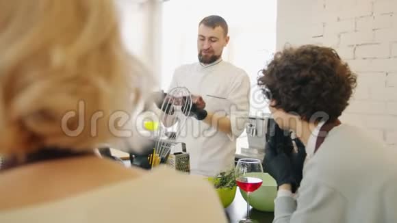 快乐的厨师在烹饪学校教人们拿着食物穿着制服说话视频的预览图