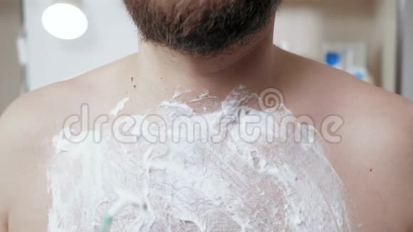 男人剃了他的胸部中年留胡子的白种人用一次性剃须刀穿过他的胸部视频的预览图