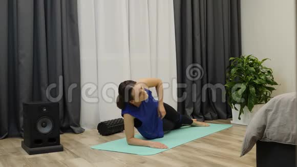 女人做侧木板集中女性在家里的垫子上做伸展瑜伽运动一位身材苗条的前男友做腹部锻炼视频的预览图