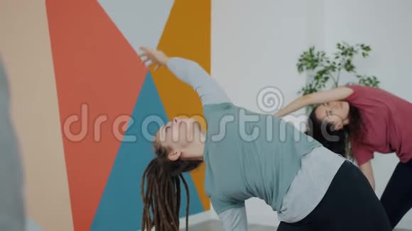漂亮的年轻女士穿着运动服在瑜伽俱乐部室内锻炼专注于体式视频的预览图