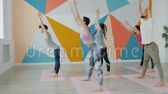 一群年轻人在瑜伽室集中练习弯曲体位视频的预览图
