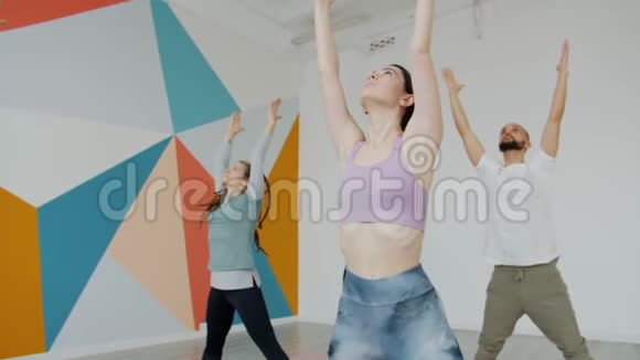 严肃的男人和女人在现代工作室上课时忙于瑜伽体式视频的预览图