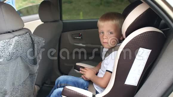 一个6岁的小男孩坐在汽车座椅上他系着安全带视频的预览图