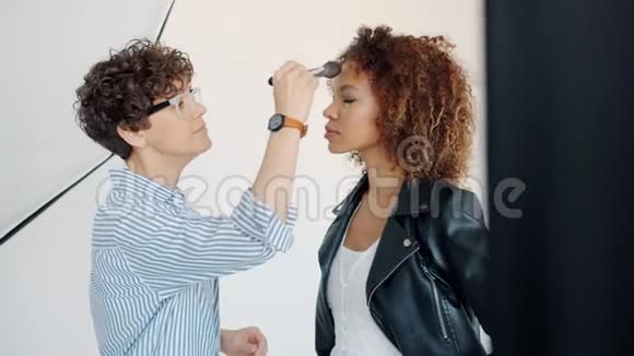 专业化妆师在摄影棚中与美国黑人模特合作视频的预览图