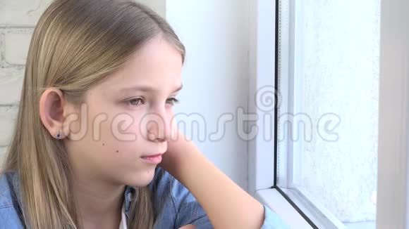 伤心的孩子看着窗户不开心的孩子无聊的体贴的女孩悲伤的少年脸视频的预览图
