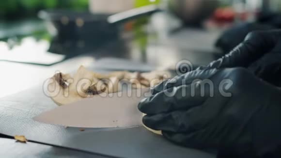男性手特写用刀切蘑菇在室内做饭视频的预览图