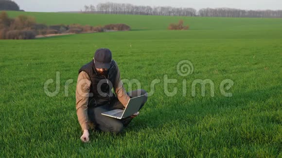 农夫在地里用笔记本电脑干活视频的预览图
