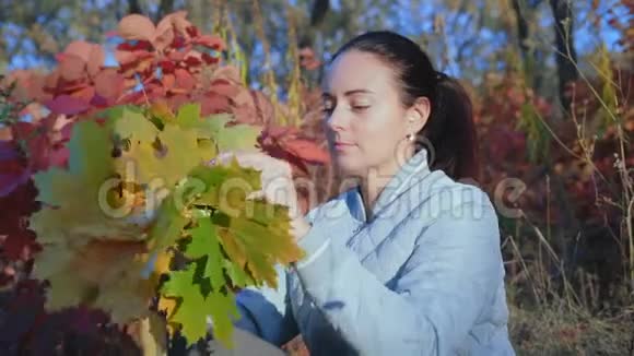 慢动作美丽的女人头上戴着秋天树叶的花环视频的预览图