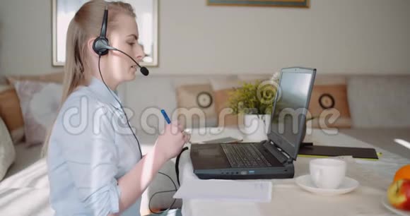 销售代表在耳机与客户交谈并在笔记本电脑上制作视频电话会议视频的预览图