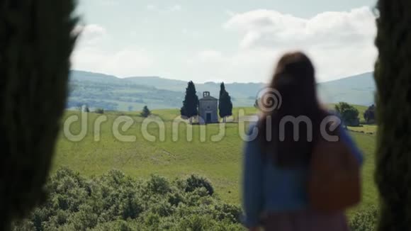 带背包的女孩站着在维塔莱塔教堂欣赏托斯卡纳风景视频的预览图