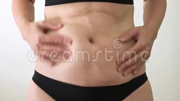 穿比基尼的白人超重胖女人用手摇动她肥胖的胃减肥的概念视频的预览图